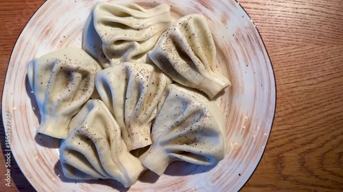 CloseUp Dumpling On Ceramic Plate, Textured Folds And Seasoning Visible, Pepper Specks And Soft Light Emphasize Pleats And Dough, Intimate Foodie Angle Ideal For Recipe Or Blog Content,