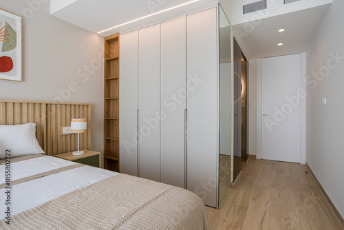 Картината върху платно Modern cozy bedroom with wood flooring, built-in wardrobe and soft natural light