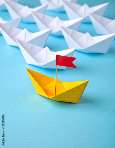 Leadership Concept with Gold Origami Boat Leading Group of White Ships
