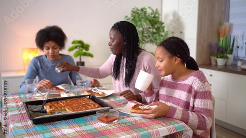 African american family eating homemade pizza at the dinner table