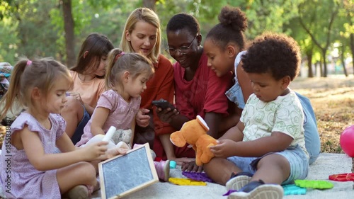 Multiracial families and friends enjoying a picnic in the park together