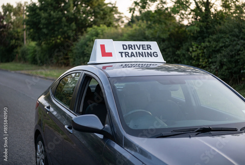 Driving school learner car with driver training sign on roof, road safety education and new driver lessons concept.