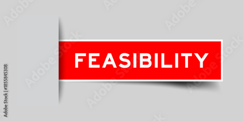 Red color square shape sticker label with word feasibility inserted in gray background