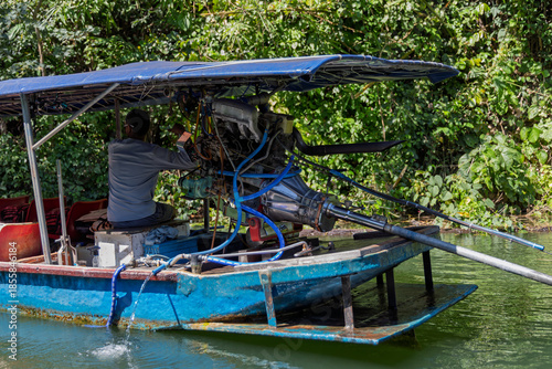 Mechanic repairing long-tail boat motor in khao yai thailand