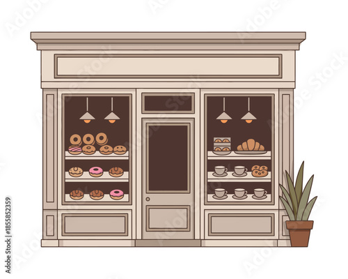 An exterior view of a charming bakery storefront displaying donuts, pastries, and coffee cups in its windows.