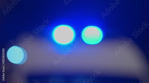 4k, Close up view of the roof of an ambulance with flashing blue warning lights, blurred, at nighttime