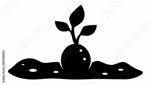 A single robust seedling sprouting from a textured mound of earth with small white dots, in silhouette.