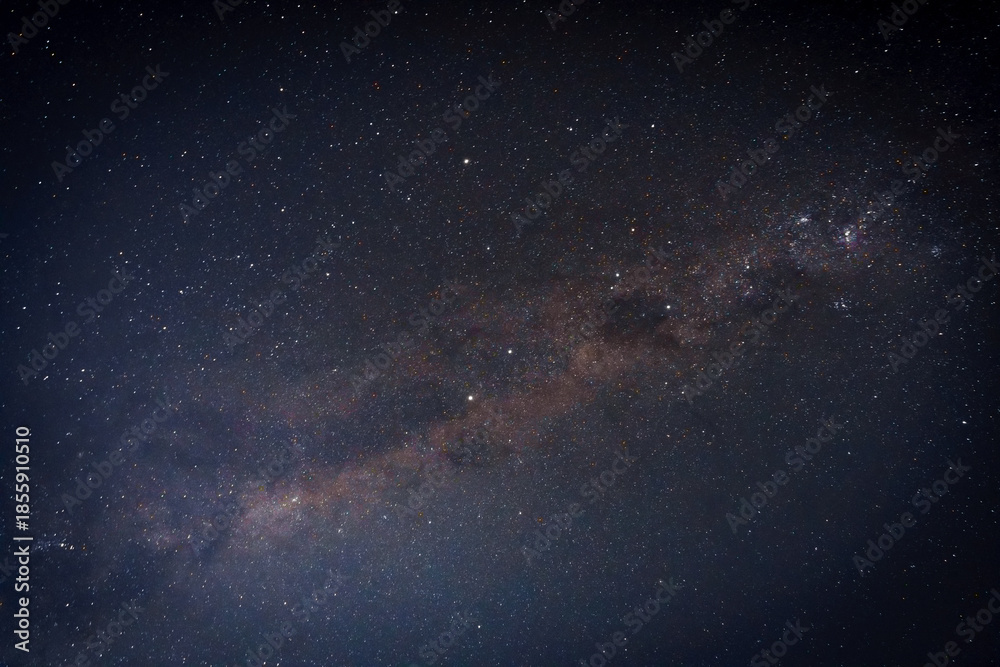 Fototapeta premium Starry night sky with visible Milky Way and star trails, creating a deep space background with cosmic motion and celestial atmosphere. Ideal for science, astronomy, and abstract space concepts.