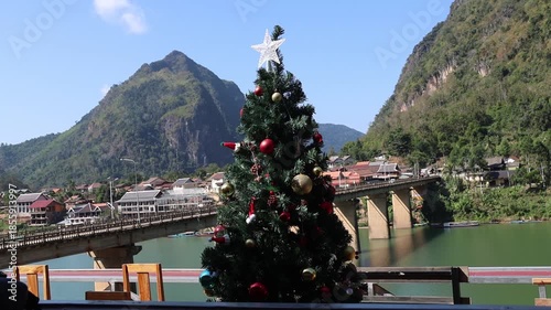 Panoramic summer landscape from a mountain top overlooking a scenic  lake and coastal village nestled between mountains and the sea under a cloudy sky