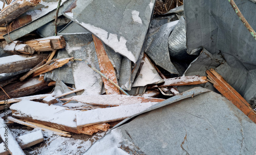 Garbage dump. Close-up of a demolished wooden house in the snow. Winter background. 
Environmental pollution.

