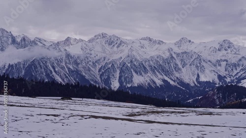 Alpine Mountains with Snow and Cloudy Sky