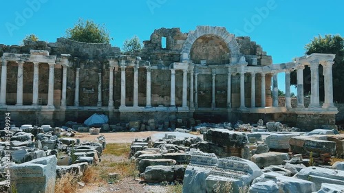 SIDE, TURKEY, June 16, 2024: Ruins of the ancient city of Side in Antalya province on the Mediterranean coast. Amazing ruins of an ancient city. Old statues in the State Agora.The ancient city wall.4K