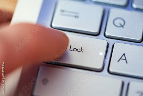 Close-up computer keyboard keys and finger, top view.