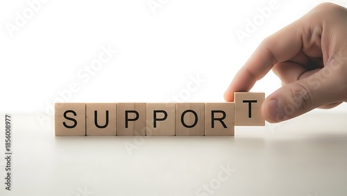 Hand Arranging Wooden Blocks Spelling the Word Support