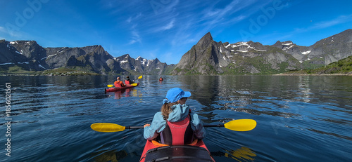 Woman With Kayak On Calm Fjord Near Hamnoy And Reine On Lofoten Islands In Norway