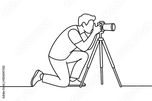 A person is kneeling down and taking a picture with a camera on a tripod.