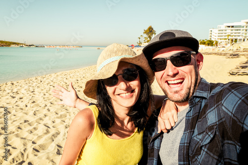 Happy traveling couple making selfie with beach background. Summer beach holidays. Romantic mood. Happy laughing emotional faces hipster multiracial. Holidays Europe