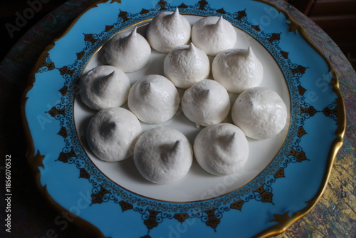 pile of white sweet meringues on a plate