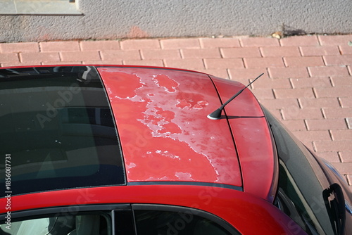 Fotografie Peeling sun-faded paint on a red car