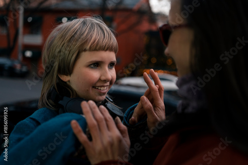 Mom and daughter at walk in winter snowless city