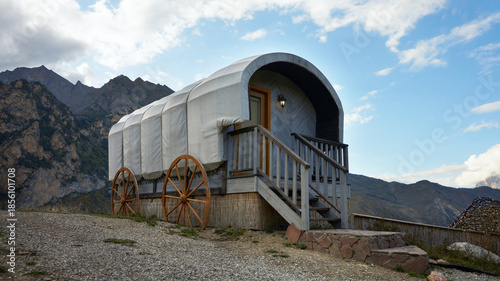 A café in a mountain gorge on the grounds of an aeroclub, styled to resemble Vardo's van. Rocky mountains are in the background.
