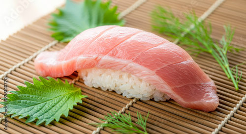 高級大トロ寿司のクローズアップ。脂ののったマグロの寿司、シソともに竹のマットに美しく盛り付けられている。