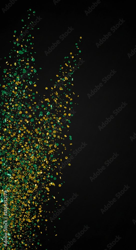 Obraz premium Cascade of gold and green confetti on a dark background, creating a festive and celebratory atmosphere, perfect for party or holiday concepts, free space