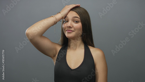 Photos Girl wearing bracelets and sleeveless top with hand on forehead and mouth open in gray studio; surprise reaction
