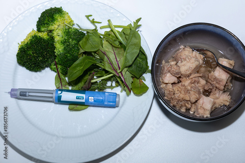Healthy salad with tuna and Ozempic pen for diet concept