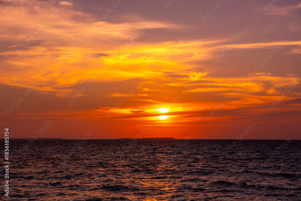 Fototapeta premium Beautiful sunset. Tranquil closeup calm sea water waves with palm trees. Tropical island beach landscape exotic shore coast. Summer vacation, holiday amazing nature, Maldives.
