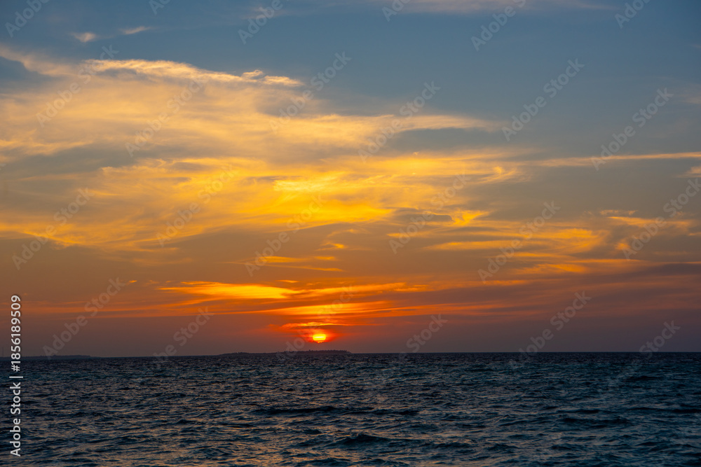 Fototapeta premium Beautiful sunset. Tranquil closeup calm sea water waves with palm trees. Tropical island beach landscape exotic shore coast. Summer vacation, holiday amazing nature, Maldives.