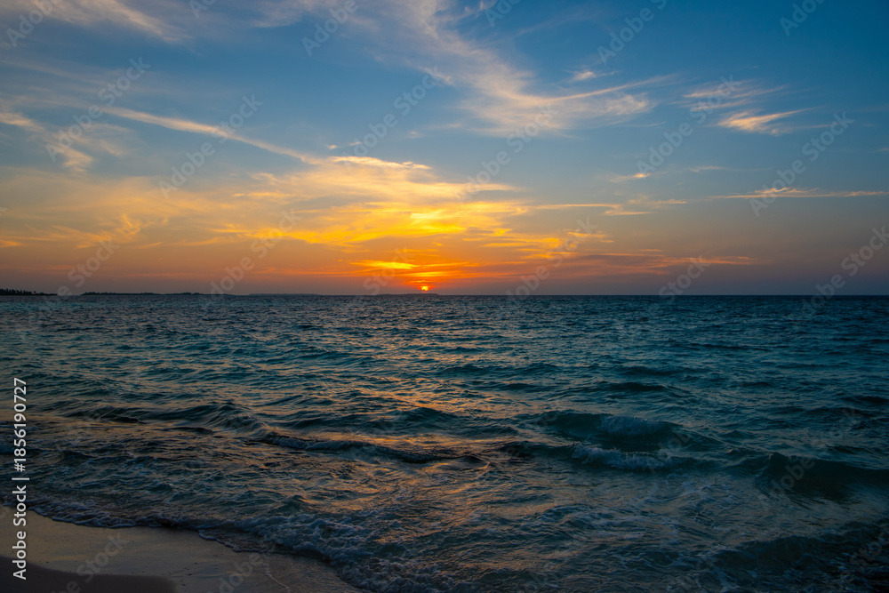 Obraz premium Beautiful sunset. Tranquil closeup calm sea water waves with palm trees. Tropical island beach landscape exotic shore coast. Summer vacation, holiday amazing nature, Maldives.