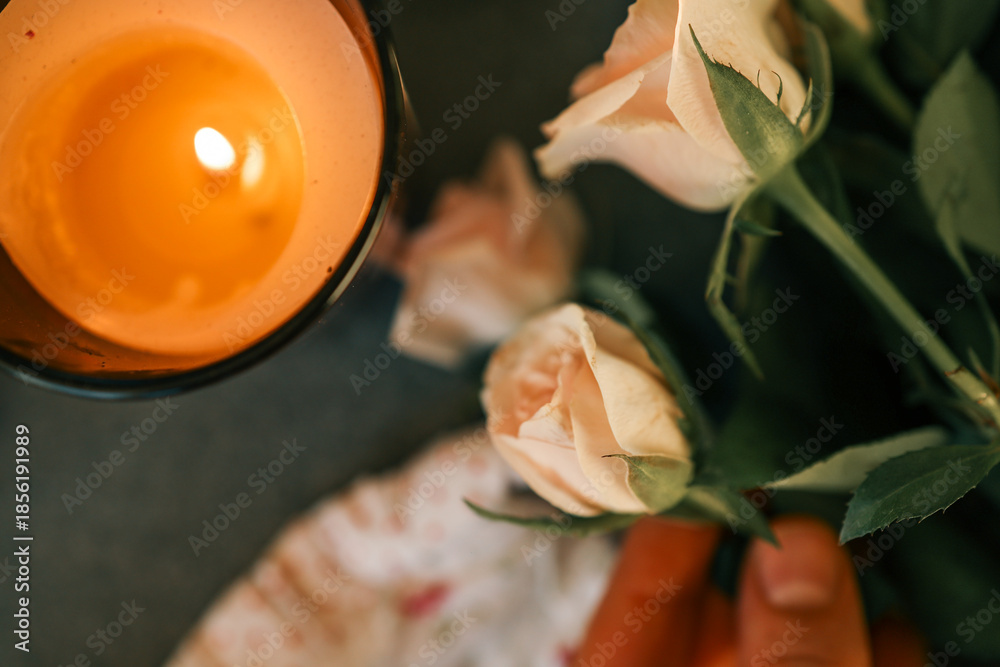 Φωτογραφία Soft peach roses and a glowing candle create a romantic and serene atmosphere