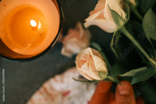 Φωτογραφία Soft peach roses and a glowing candle create a romantic and serene atmosphere