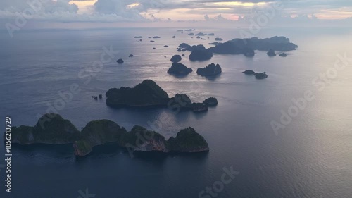 Sunrise illuminates rock islands, composed of ancient, uplifted reefs, rising from the seascape in Misool, Indonesia. This region harbors spectacular marine biodiversity and is popular for diving.