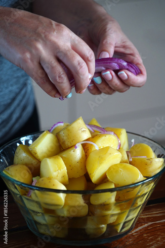 A woman prepares a delicious fresh potato salad