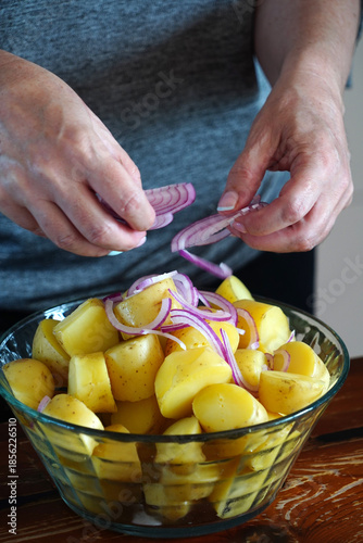 A woman prepares a delicious fresh potato salad
