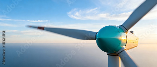 Close-up of rotating blades of powerful wind turbine against clear sunset sky, representing environmentally friendly green energy and sustainable development of global power plants.