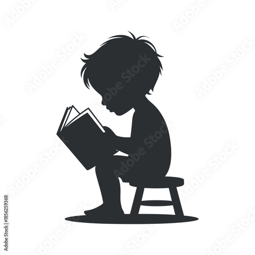 A silhouette of a young child engrossed in reading a book while seated on a small stool