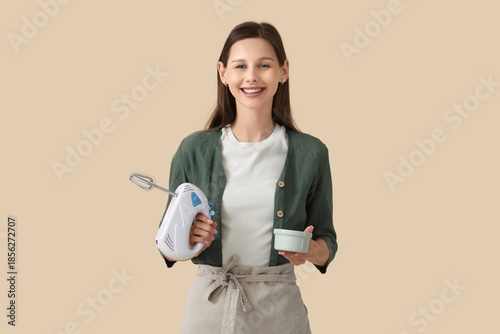Young woman with mixer and ...