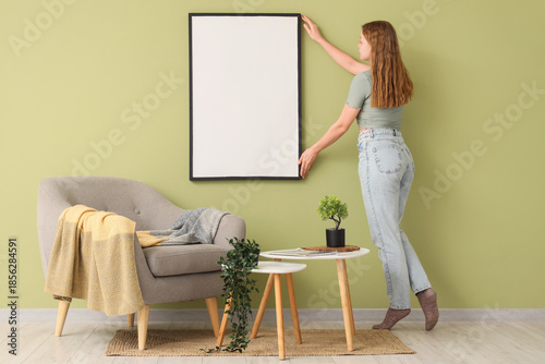 Young woman hanging blank f...