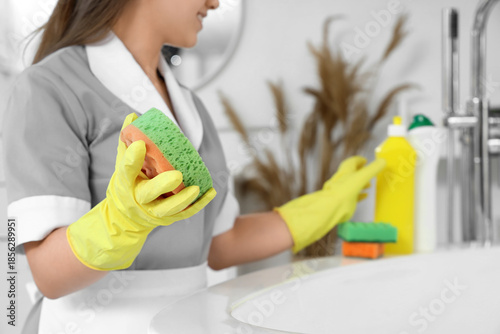 Young janitor cleaning bath...