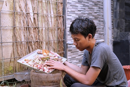 Young Gen Z individual composting kitchen waste at home, practicing sustainable living and eco-friendly habits to reduce household waste and support environmental awareness.