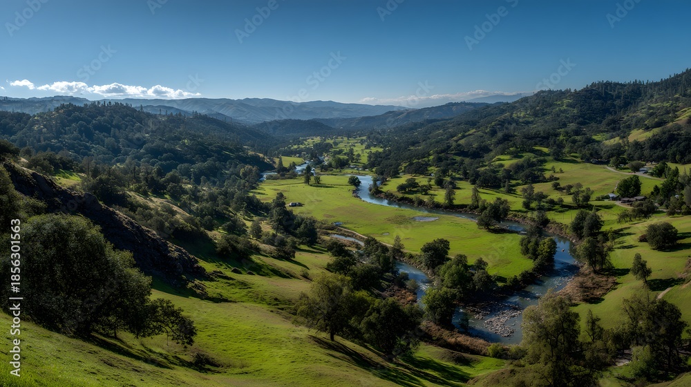 Naklejka premium Scenic Rolling Hills with Green Valleys and Distant Buildings Under a Blue Sky.