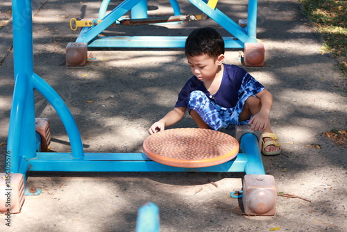 Portrait of a children in a park, A 3-year-old boy is happily walking in the park, wearing an Asian-style blue and white shirt.