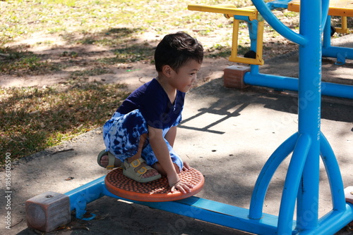 Portrait of a children in a park, A 3-year-old boy is happily walking in the park, wearing an Asian-style blue and white shirt.