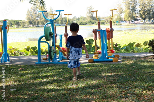Portrait of a children in a park, A 3-year-old boy is happily walking in the park, wearing an Asian-style blue and white shirt.