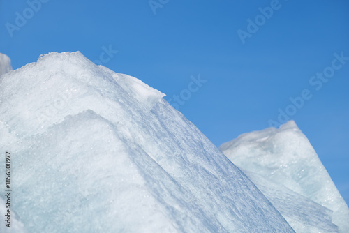 Ice pyramids on blue sky background.