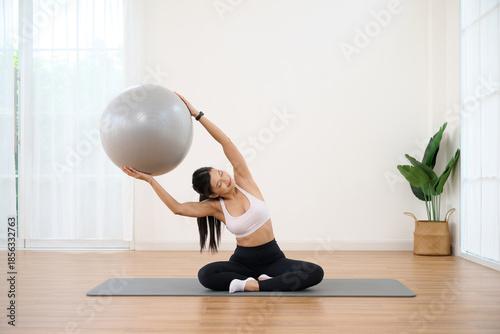 Woman is exercising with a large yoga ball