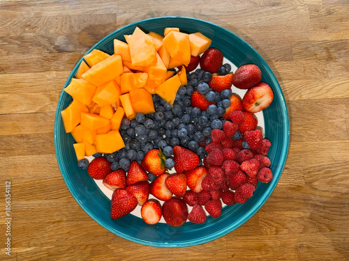 Above angle view of Christmas bowl with cantaloupe, blueberries and strawberries